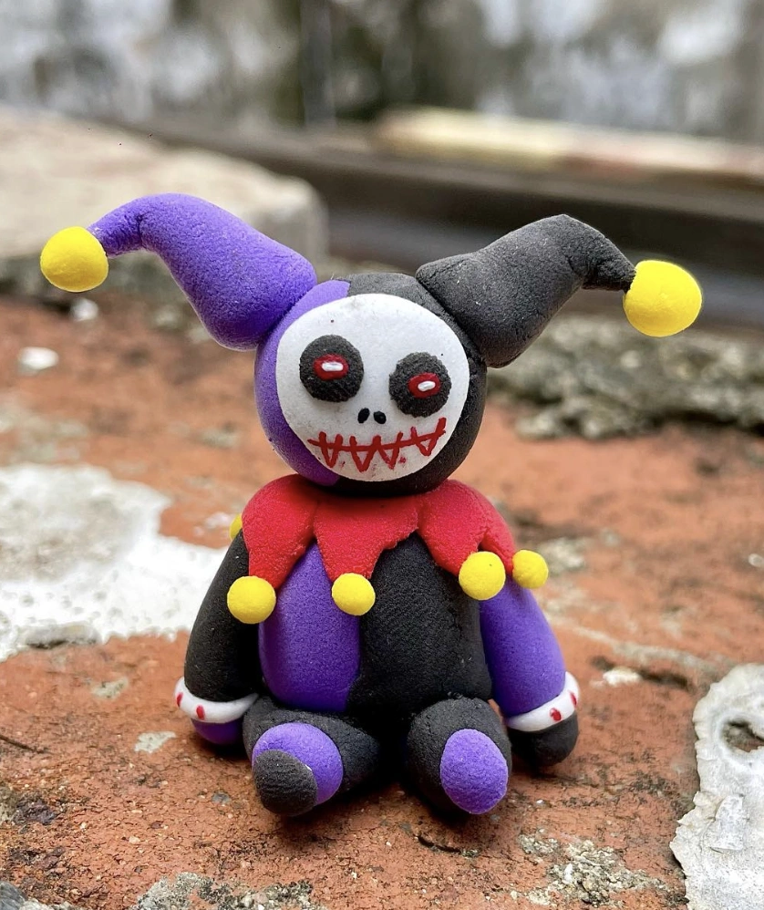 Adorable Witch Figurine Surrounded by Clay Pumpkins and Ghosts